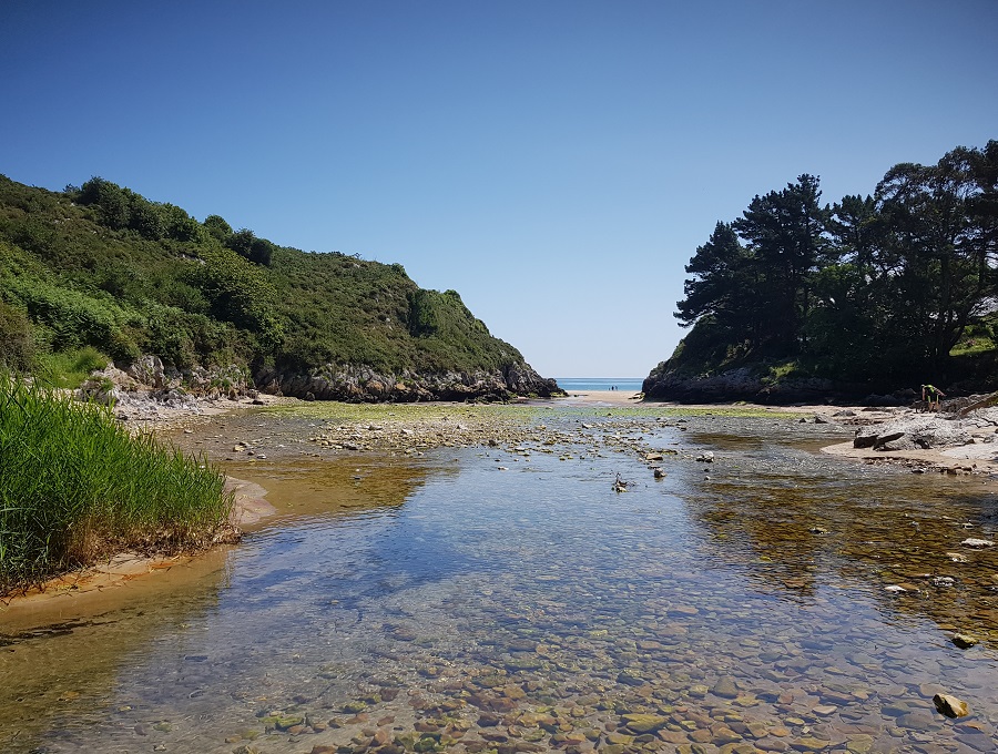 Al fondo, la playa de La Huelga, desde la desembocadura del río San Cecilio, con bajamar